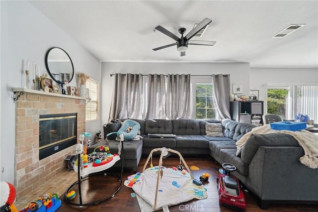 living room featuring visible vents, wood finished floors, a wealth of natural light, and a fireplace