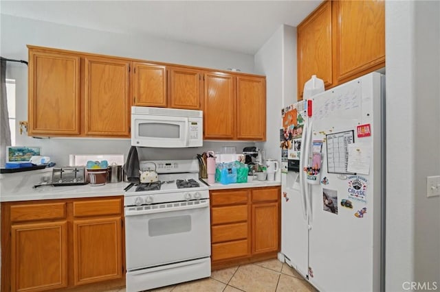 kitchen featuring light countertops, brown cabinetry, white appliances, and light tile patterned flooring