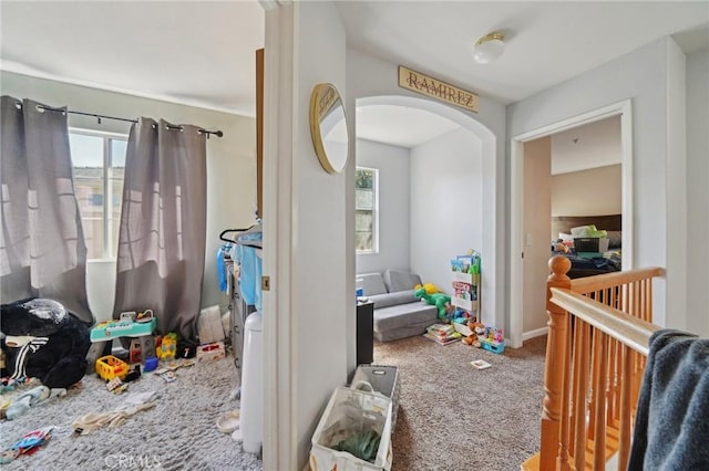 playroom with a healthy amount of sunlight, arched walkways, and carpet floors