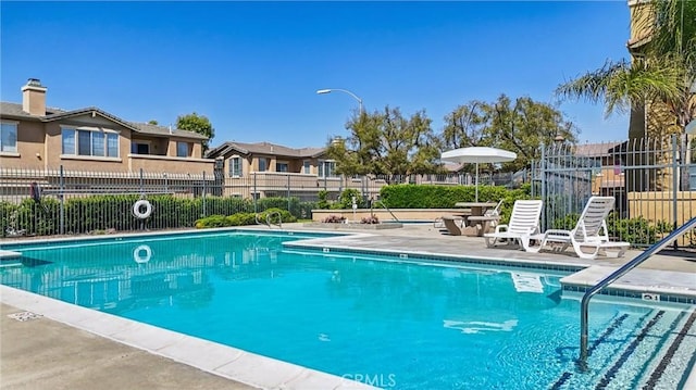 community pool featuring a patio and fence