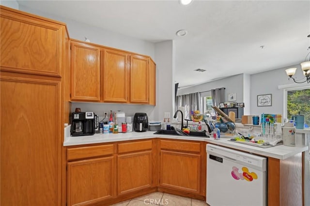kitchen with dishwasher, a sink, light countertops, a peninsula, and an inviting chandelier