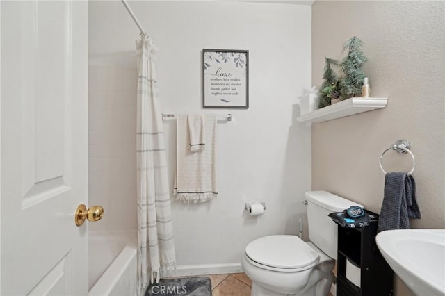 bathroom featuring tile patterned flooring, a sink, baseboards, toilet, and shower / bath combo with shower curtain