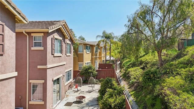 exterior space with a patio area, stucco siding, and fence