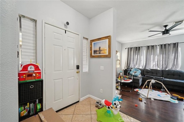 entrance foyer with baseboards, ceiling fan, and light tile patterned floors