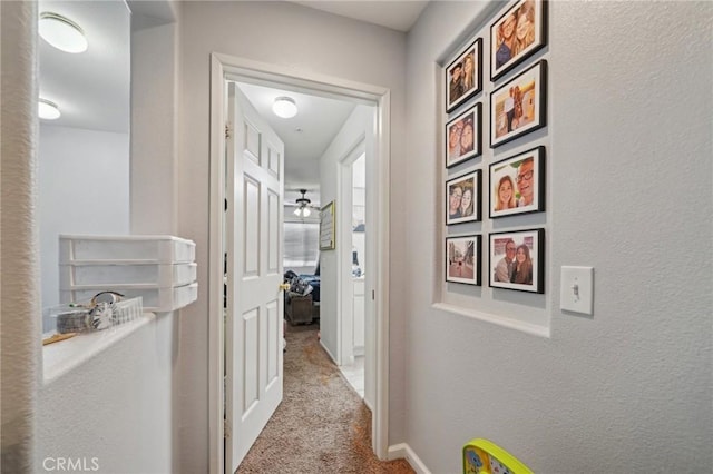 hallway featuring carpet floors and baseboards