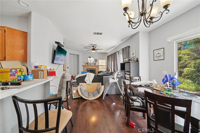 dining room with dark wood-style floors, visible vents, plenty of natural light, and a glass covered fireplace