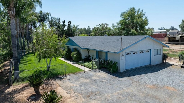 ranch-style home with an attached garage, a front lawn, fence, and driveway