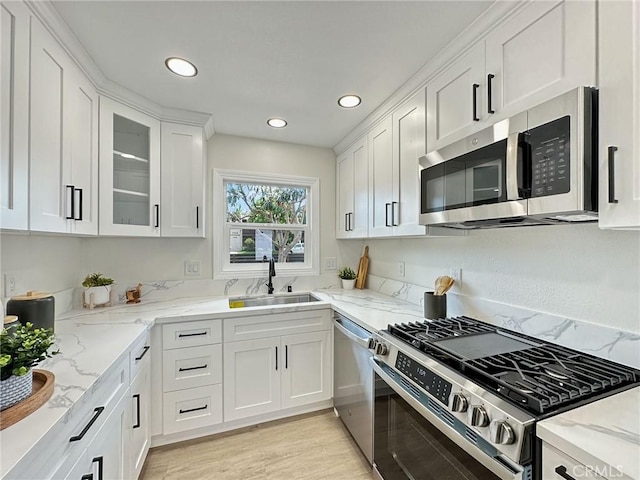 8611 Chapman Ave, Garden Grove, CA 92841 - kitchen featuring stainless steel appliances, a sink, white cabinetry, recessed lighting, and glass insert cabinets