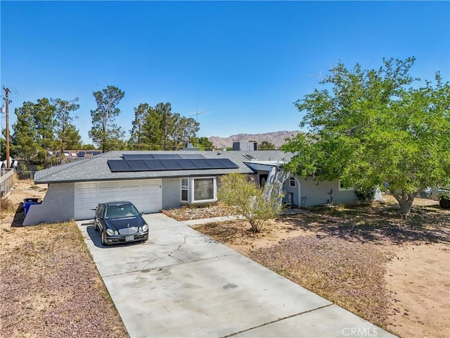 14544 Jelan Ave, Apple Valley, CA 92307 - view of front of property with a mountain view, an attached garage, solar panels, and driveway