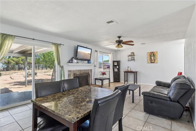 14544 Jelan Ave, Apple Valley, CA 92307 - dining area featuring a ceiling fan, a tile fireplace, light tile patterned flooring, and visible vents