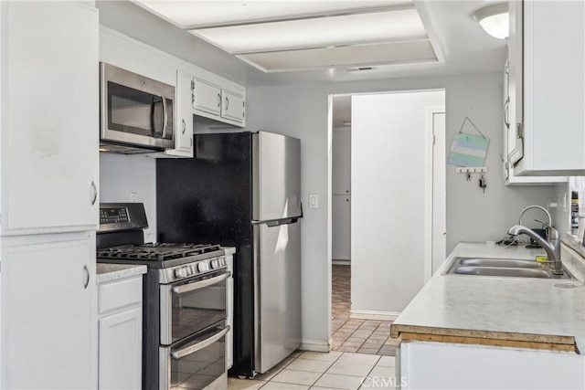 14544 Jelan Ave, Apple Valley, CA 92307 - kitchen featuring white cabinets, a sink, light countertops, stainless steel appliances, and light tile patterned floors
