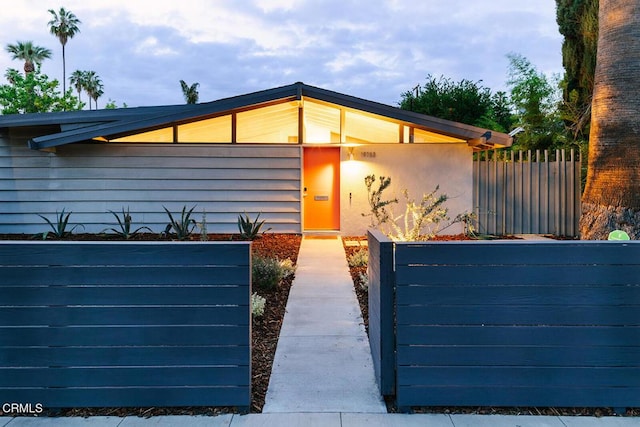view of front of home with fence and stucco siding