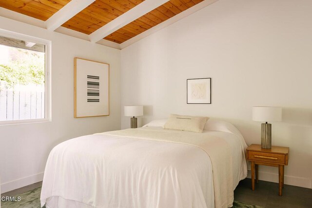bedroom with baseboards, lofted ceiling with beams, and wood ceiling