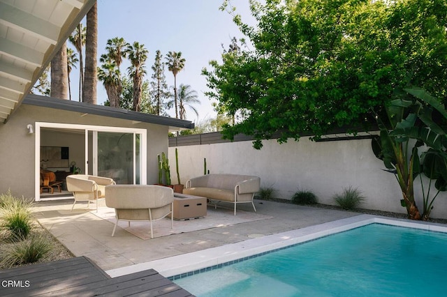 view of pool with a fenced in pool, fence, an outdoor living space, and a patio area