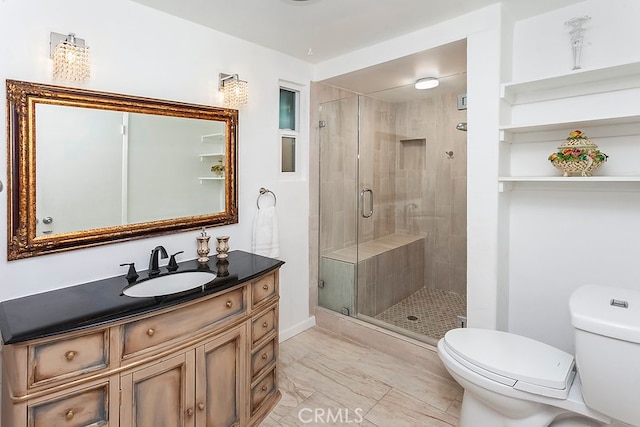 bathroom with a shower stall, vanity, baseboards, toilet, and marble finish floor