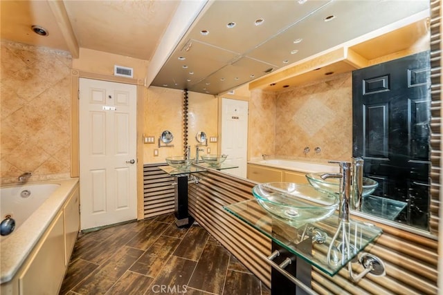 full bath with tile walls, visible vents, a bath, and vanity