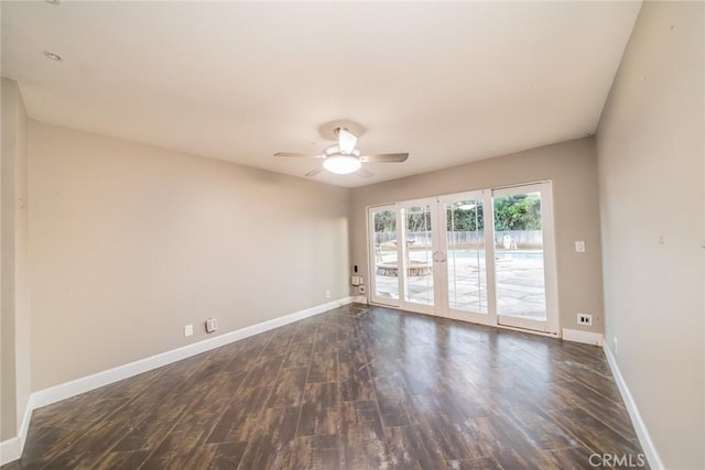 empty room featuring baseboards, a ceiling fan, and dark wood-style flooring