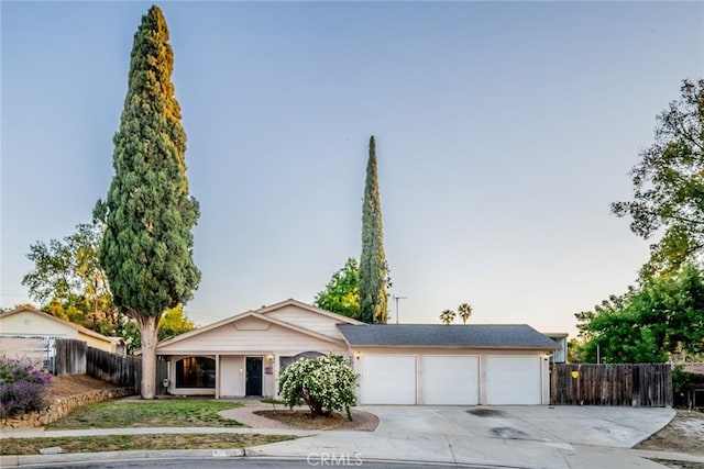 single story home featuring fence, an attached garage, and concrete driveway