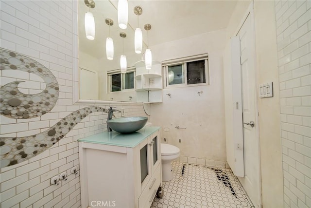 bathroom featuring vanity, tile patterned floors, toilet, and tile walls