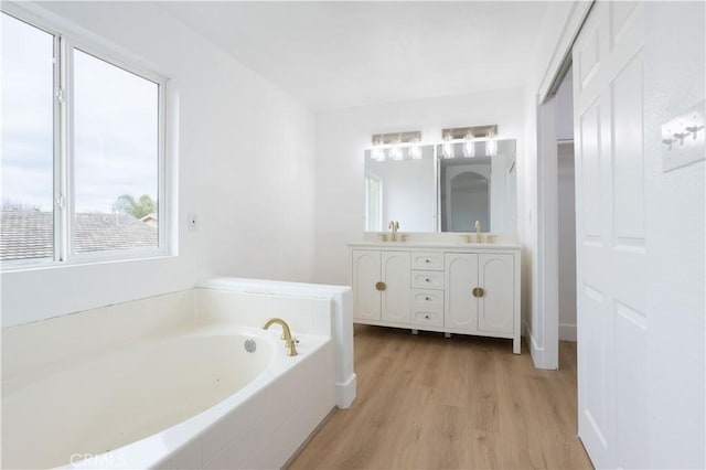 347 Beckes St, Wasco, CA 93280 - bathroom featuring a sink, double vanity, a garden tub, and wood finished floors