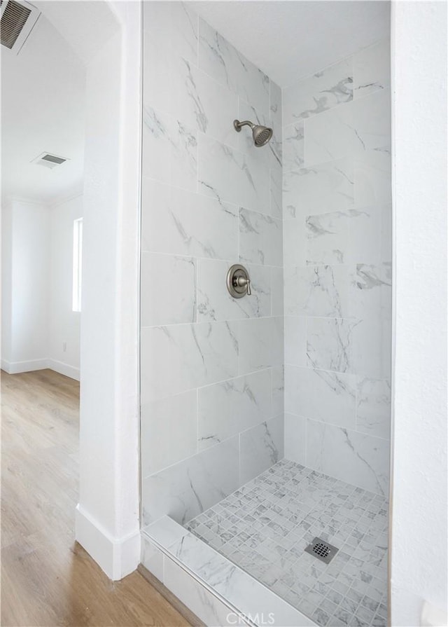 347 Beckes St, Wasco, CA 93280 - full bathroom with baseboards, wood finished floors, a tile shower, and visible vents