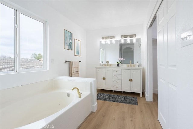 347 Beckes St, Wasco, CA 93280 - full bathroom featuring double vanity, a sink, wood finished floors, and a garden tub