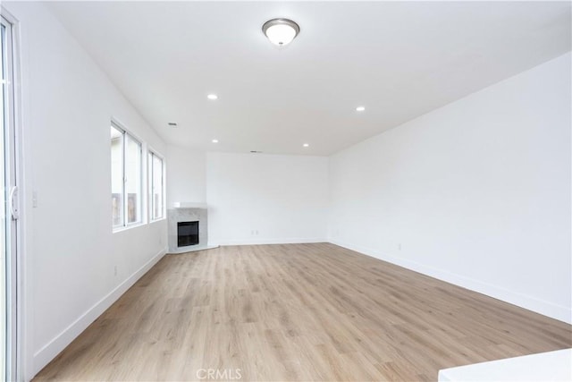 347 Beckes St, Wasco, CA 93280 - unfurnished living room featuring recessed lighting, baseboards, light wood-style flooring, and a fireplace