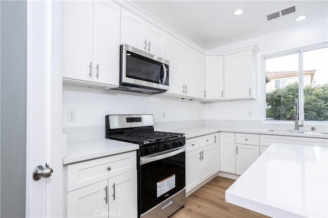 347 Beckes St, Wasco, CA 93280 - kitchen featuring white cabinets, a sink, light countertops, stainless steel appliances, and visible vents