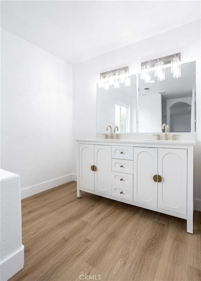 347 Beckes St, Wasco, CA 93280 - bathroom with a sink, baseboards, double vanity, and wood finished floors
