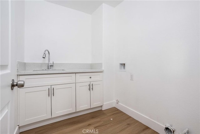 347 Beckes St, Wasco, CA 93280 - laundry area featuring washer hookup, a sink, gas dryer hookup, baseboards, and light wood-type flooring