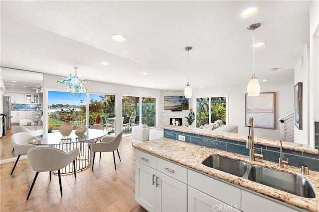kitchen with light wood-style floors, a sink, a wealth of natural light, and open floor plan