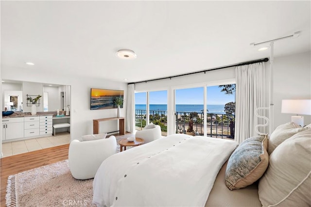 bedroom featuring light wood-style floors, access to outside, ensuite bathroom, and recessed lighting