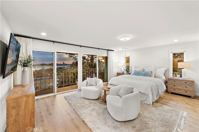 bedroom with recessed lighting, wood finished floors, and access to exterior