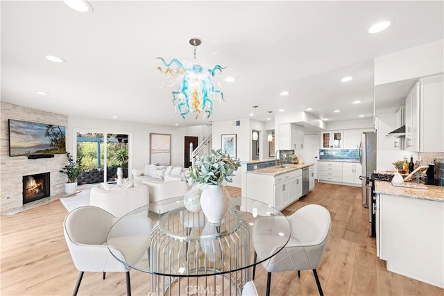 dining space with recessed lighting, light wood-style flooring, visible vents, and a fireplace