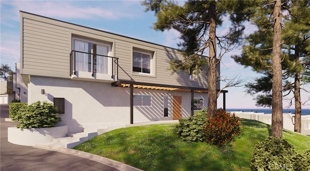 exterior space with a water view and stucco siding