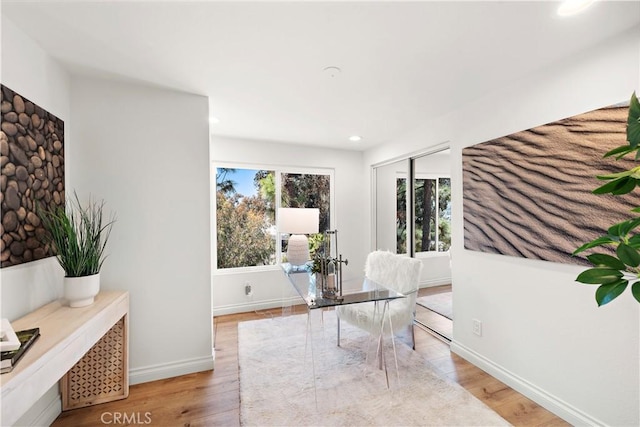interior space with recessed lighting, baseboards, plenty of natural light, and light wood-type flooring