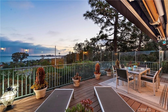 deck at dusk featuring outdoor dining area