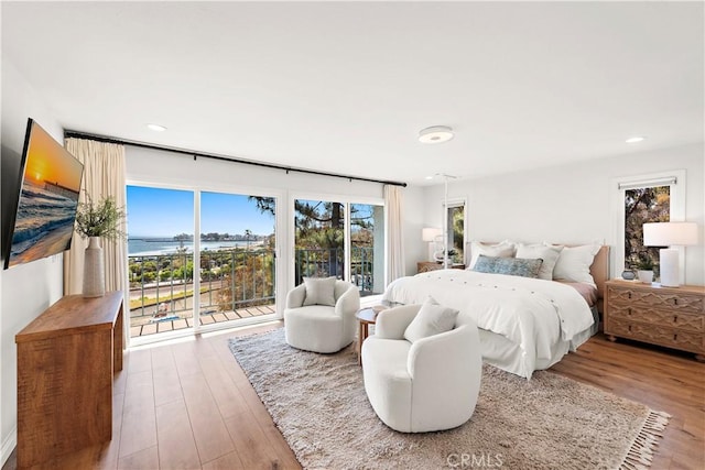 bedroom with access to outside, recessed lighting, and wood finished floors