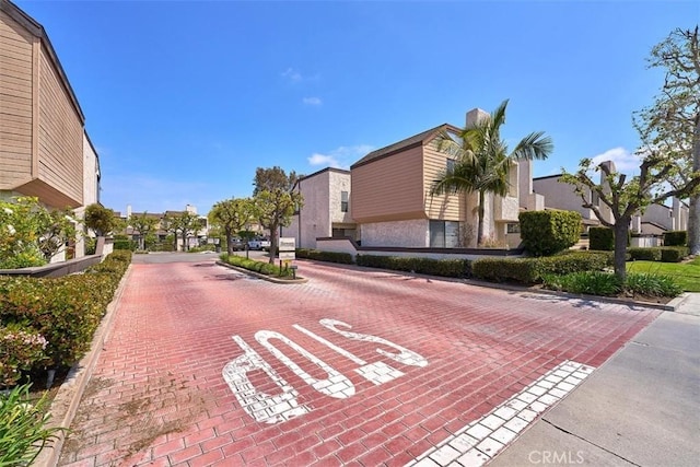 view of road with a residential view and curbs