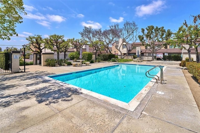 pool with a residential view, fence, and a patio area