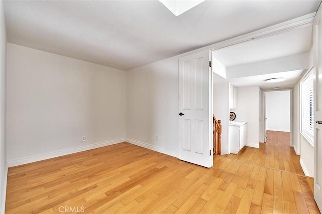 spare room with light wood-style floors and baseboards