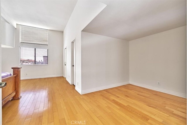 unfurnished room with baseboards and light wood-type flooring