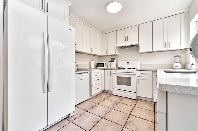 kitchen featuring light tile patterned floors, a sink, white cabinets, under cabinet range hood, and white appliances