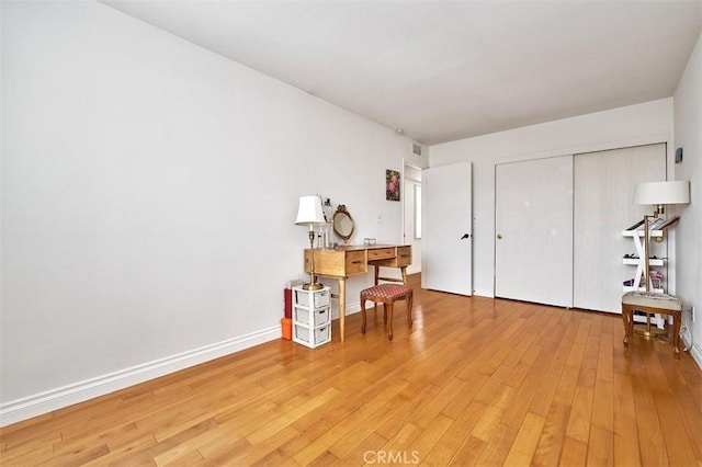 office with baseboards, light wood finished floors, and visible vents
