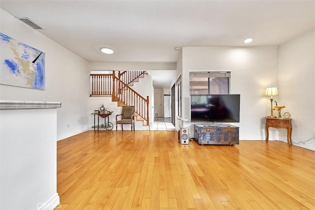 living area featuring visible vents, stairway, baseboards, wood-type flooring, and recessed lighting