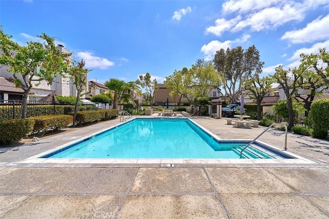 pool featuring a patio, fence, and a residential view