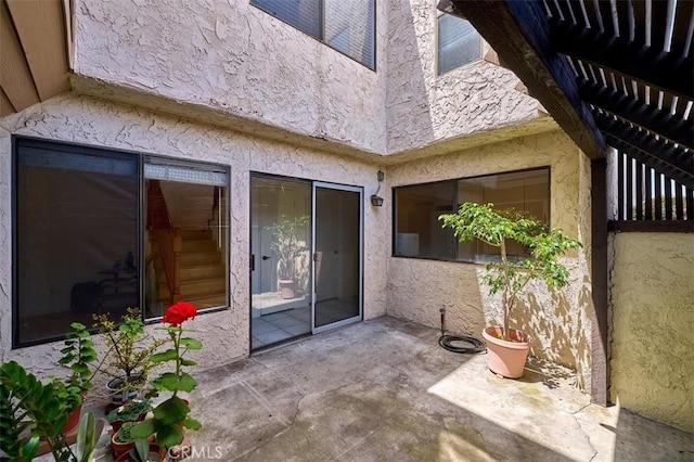doorway to property with a patio and stucco siding