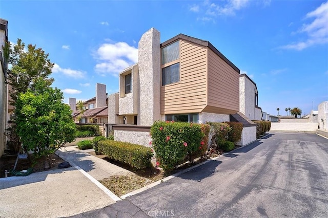 view of property exterior with a residential view and a chimney