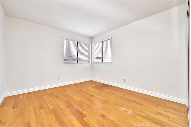 unfurnished room featuring light wood-type flooring and baseboards