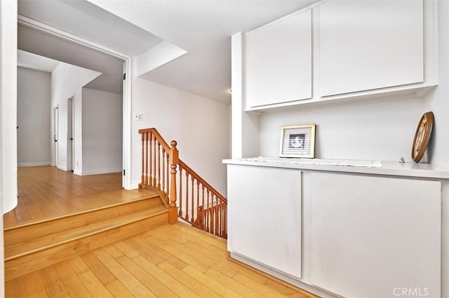 stairway featuring baseboards and hardwood / wood-style flooring